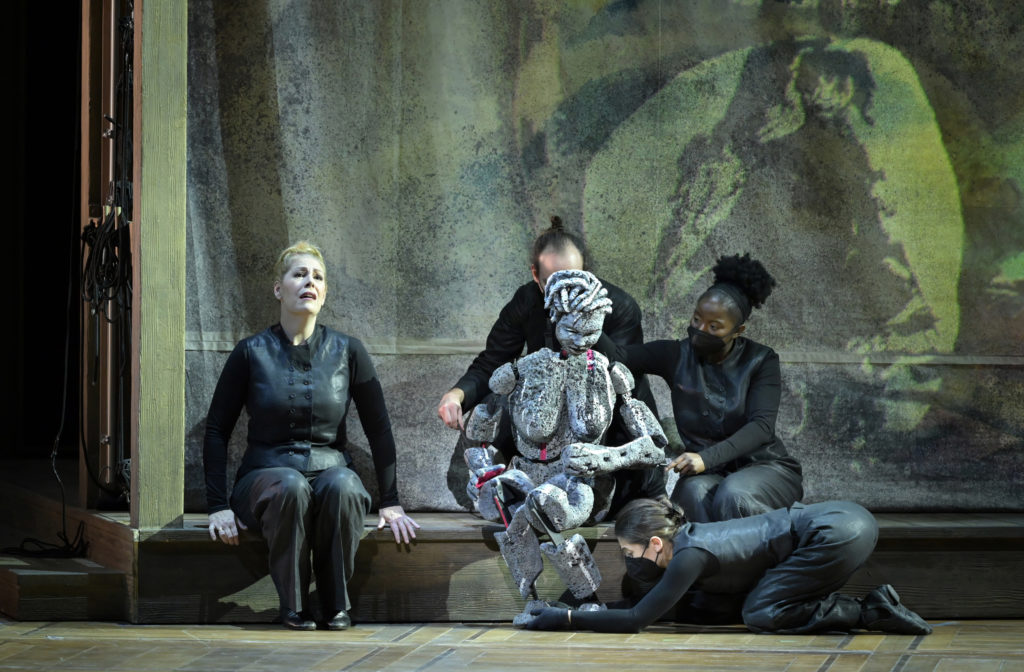 Scène au Temple d'Isis avec la soprano Sondra Radvanovsky, les marionnettistes et la marionnette d'Aïda, toile de Virginia Chihota en arrière plan, Aida de Giuseppe Verdi, mise en scène Lotte de Beer, Opéra de Paris, 2021. Photo Vincent Pontet.