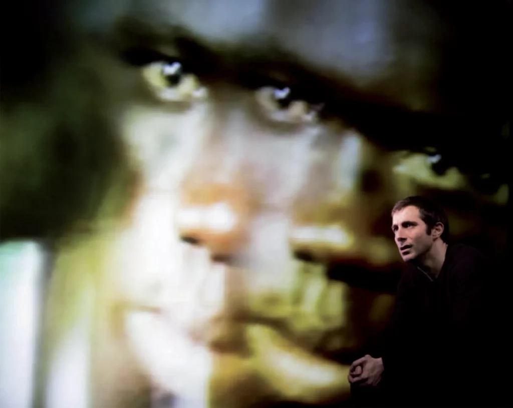 Stéphane Facco dans PULVÉRISÉS d’Alexandra Badea, mise en scène par Aurélia Guillet et Jacques Nichet, Théâtre National de Strasbourg, février 2014. Photo Franck Beloncle. Photo du visage projeté Alfredo Caliz-Rea & Mathilde Germi.
