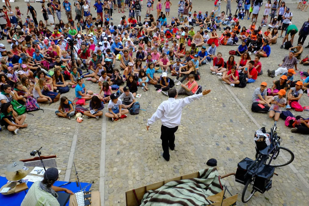 Un spectacle de rue pendant un séjour « Avignon Enfants à l’honneur », organisé par Scènes d’enfance-Assitej France. Crédit : Scènes d’enfance. 5-Des enfants sur la scène, dans la cour d’honneur du Palais des papes, pendant une édition d’ « Avignon Enfants à l’honneur », organisé par Scènes d’enfance-Assitej France. Crédit : Scènes d’enfance.